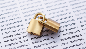 Two brass padlocks resting on a printed sheet of numbers, representing data security and confidential information protection.